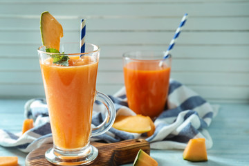 Glass of fresh melon smoothie on board