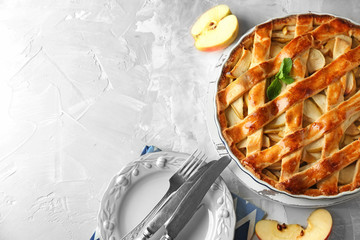 Board with delicious apple pie on light table