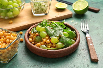 Plate with healthy fresh salad on color table