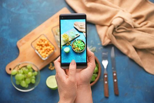 Woman taking photo of healthy salad with mobile phone, closeup