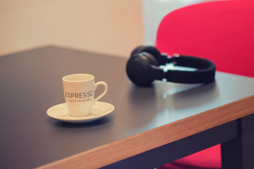headphones with cup of coffee for espresso  in a cafe. Concept