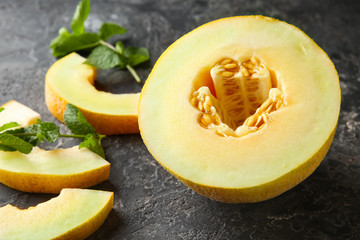 Sliced ripe melon on dark textured table