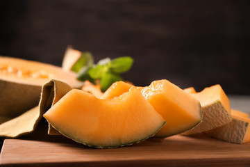 Pieces of cut ripe melon on wooden board, closeup