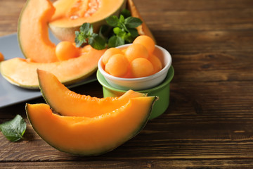 Cut ripe melon and balls on wooden table