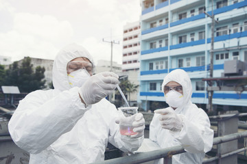 Two scientists checking water quality in wastewater treatment system.