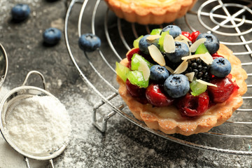 Delicious tart with fruit and berries on cooling rack