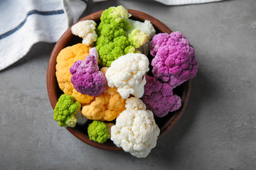 Plate with colorful cauliflowers on grey table
