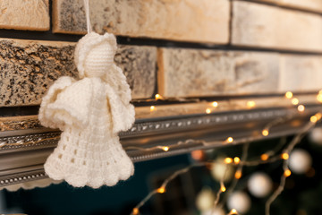 Knitted toy angel near brick wall