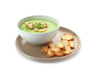 Tasty zucchini soup with croutons in bowl on white background