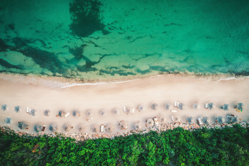 Aerial drone view of a beautiful island beach with white sand and umbrellas