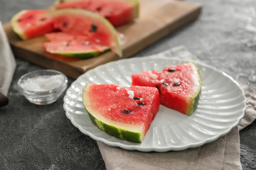 Plate with slices of watermelon on grunge background