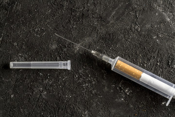 The concept of combating smoking, fighting with nicotine addiction. Cigarettes and medical syringes for injections on a dark background. Drug addiction. Smoking concept