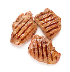 Tasty grilled steaks on white background