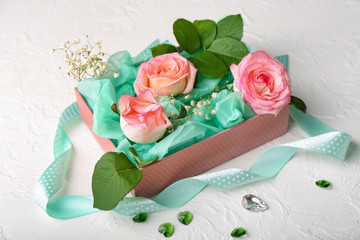 Beautiful roses in gift box on white table
