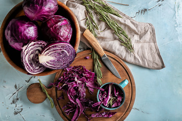 Bowl and board with chopped red cabbage on light table