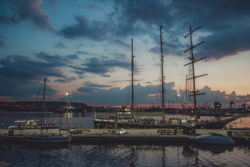 Fototapeta na wymiar Yacht port and beautiful sunset over Varna, Bulgaria. Sailboat harbor, many beautiful moored sail yachts in the sea