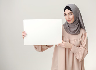 Your offer here. Woman in hijab holding white banner