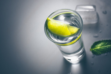 At the party a shot of vodka with lime on a glass table