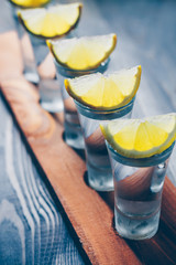 Vertical view of a vodka shot with a lemon at a party