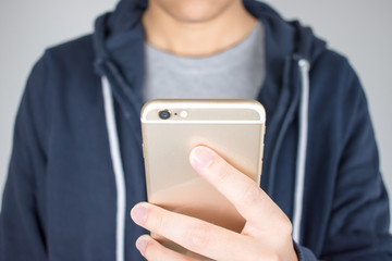 Closer hands are holding the phones are shopping online.