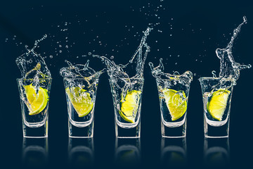 Vodka, tequila, gin in a shot glass, lime drops into the glass, splashes in all directions, crazy...