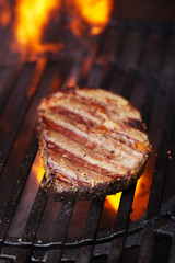ribeye rib eye roast beef steak on bbq barbecue grill with flame