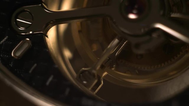 Mechanism of a watch with jewels. Open clockwork and fragments of shiny gears. Close up 4k macro shot. Time and work concept.