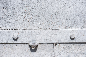 detail of old metal gate with scratched weathered white paint