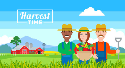 Obraz premium harvest time . farmers team with vegetables basket standing in field. organic agriculture