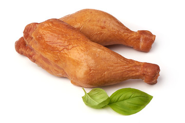 Smoked chicken legs with basil leaves, isolated on white background.