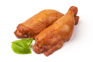 Smoked chicken drumsticks with basil leaves, isolated on white background.