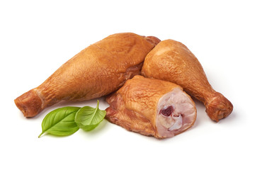 Smoked chicken drumsticks with basil leaves, isolated on white background.