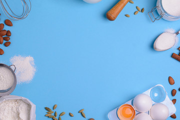 Baking ingredients for homemade pastry on blue background. Bake sweet cake dessert concept. Top view. Flat lay. Copy space