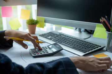 Woman using calculator while working for financial documents
