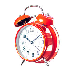 Red vintage alarm clock with bells and a hammer isolate on a white background half-turned