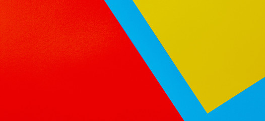 Color papers geometry flat composition background with yellow red and blue tones