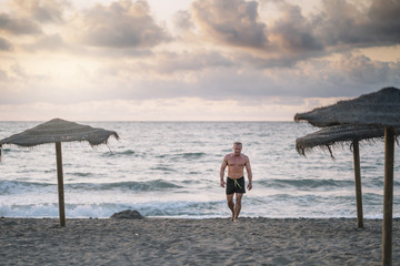 Strong old man walking on the beach