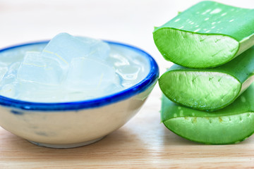 Fresh aloe vera leaves with aloe vera juice in bottle on wooden background