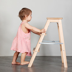 little girl pushes the ladder