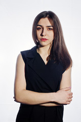 Close-up emotional portrait of a brunette girl in black jumpsuit on white background.