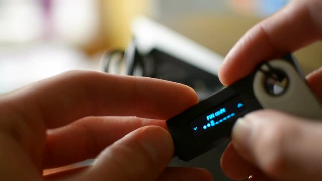 Accessing Ledger cold hardware Bitcoin cryptocurrency wallet by entering secure PIN code