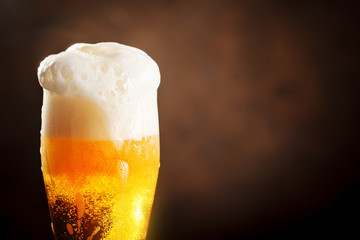A glass of beer on a dark background.