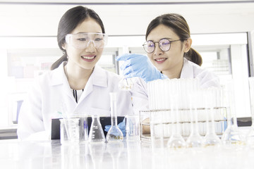 Fototapeta premium Interior of clean modern white medical or chemical laboratory background.Laboratory scientists working at lab with test tubes and report. Laboratory concept with Asian woman chemists.