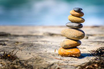 Fototapeta na wymiar Stacked stones naturally balanced on a sunny day by the beach. Rock Balancing.