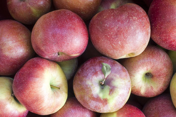 Pile of ripe red apples closeup. Natural background
