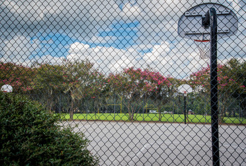 Outdoor basketball Court through Fence 