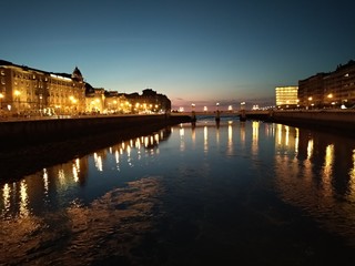 Obraz premium Río de una ciudad alumbrado por la noche.