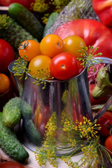 Fototapeta na wymiar Cherry tomatoes in a metallic jug surrounded by different vegetables