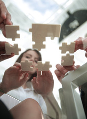 bottom view. business team folding puzzle pieces. .