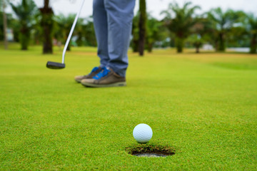 Golfer putting golf ball on the green golf, lens flare on sun set evening time, Pro Golf long...